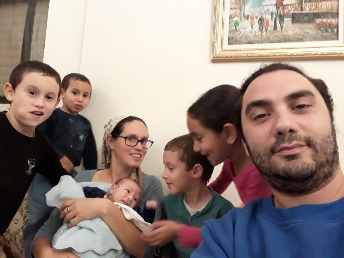 רונן וחנה בורוכוב עם ששת ילדיהם בסלון הבית